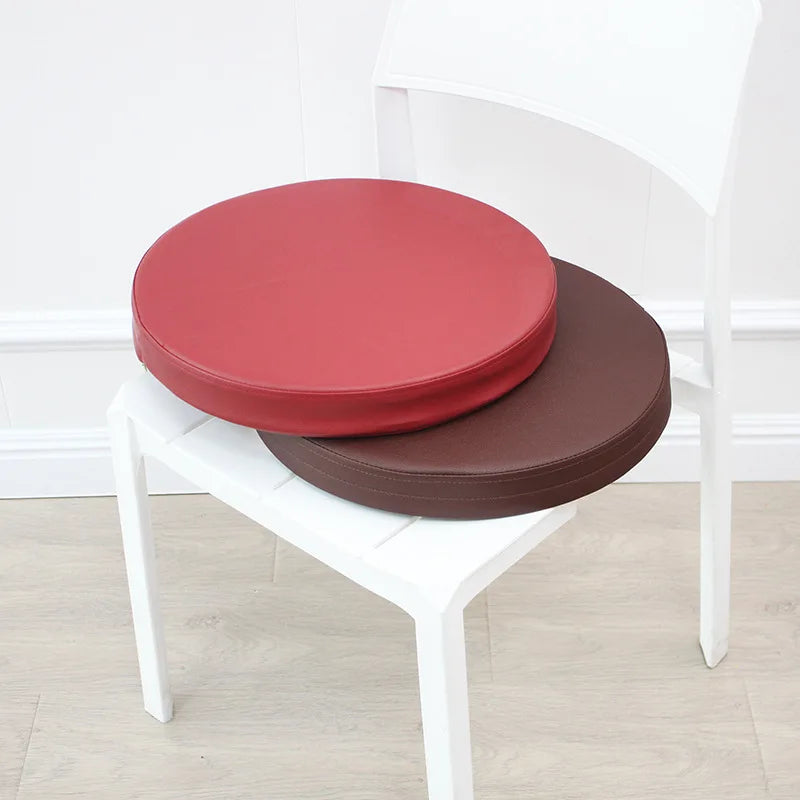 Luxueuze meditatiekussens van THE MUSCLE SHOP in rood en bruin op een witte stoel voor ultiem comfort en ondersteuning tijdens meditatie.